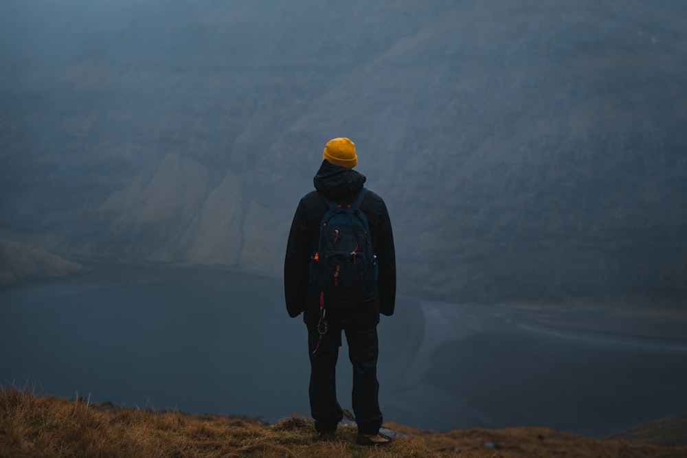 shallow focus photo of person in black hoodie wearing orange knit cap