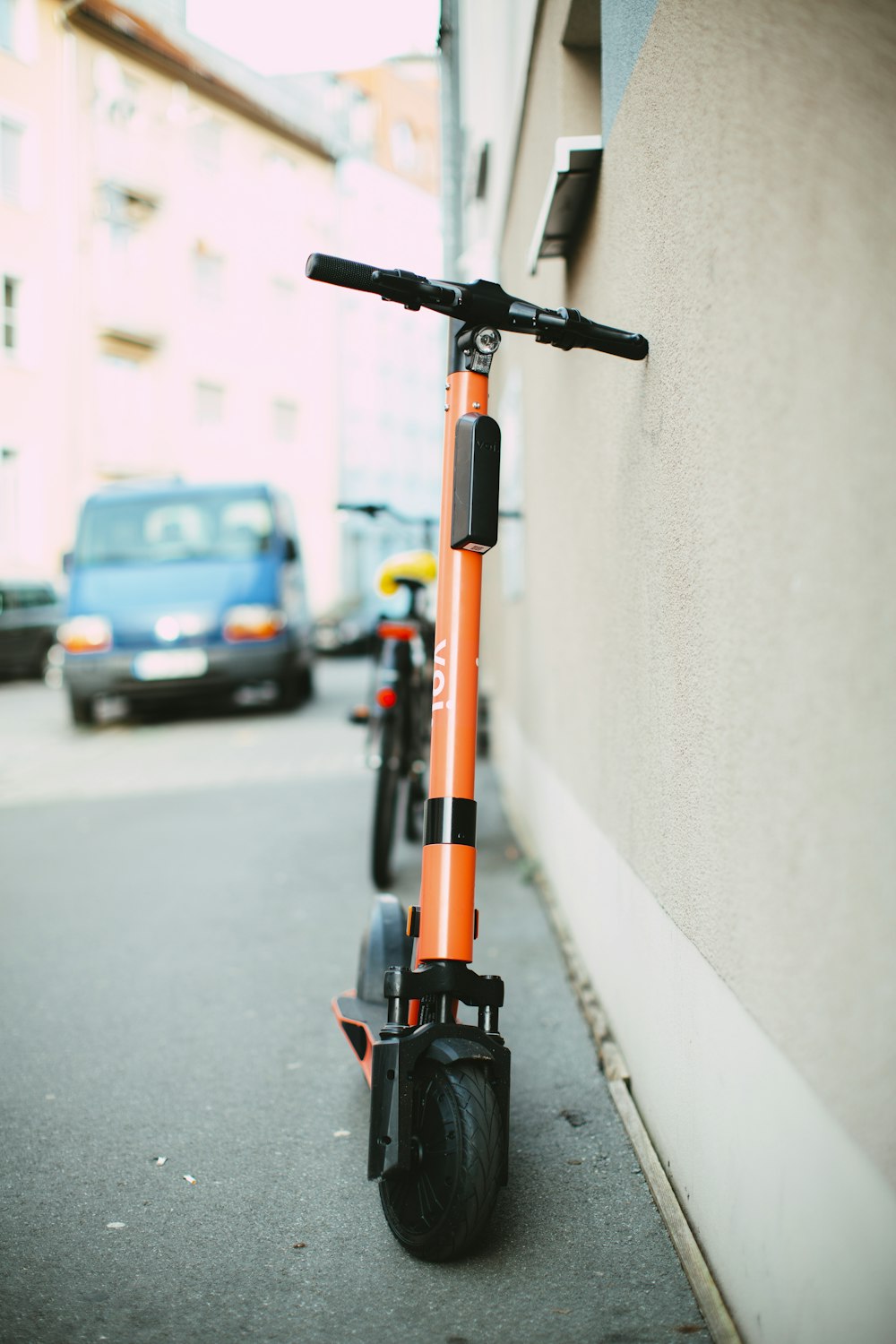 black and orange scooter parked on sidewalk