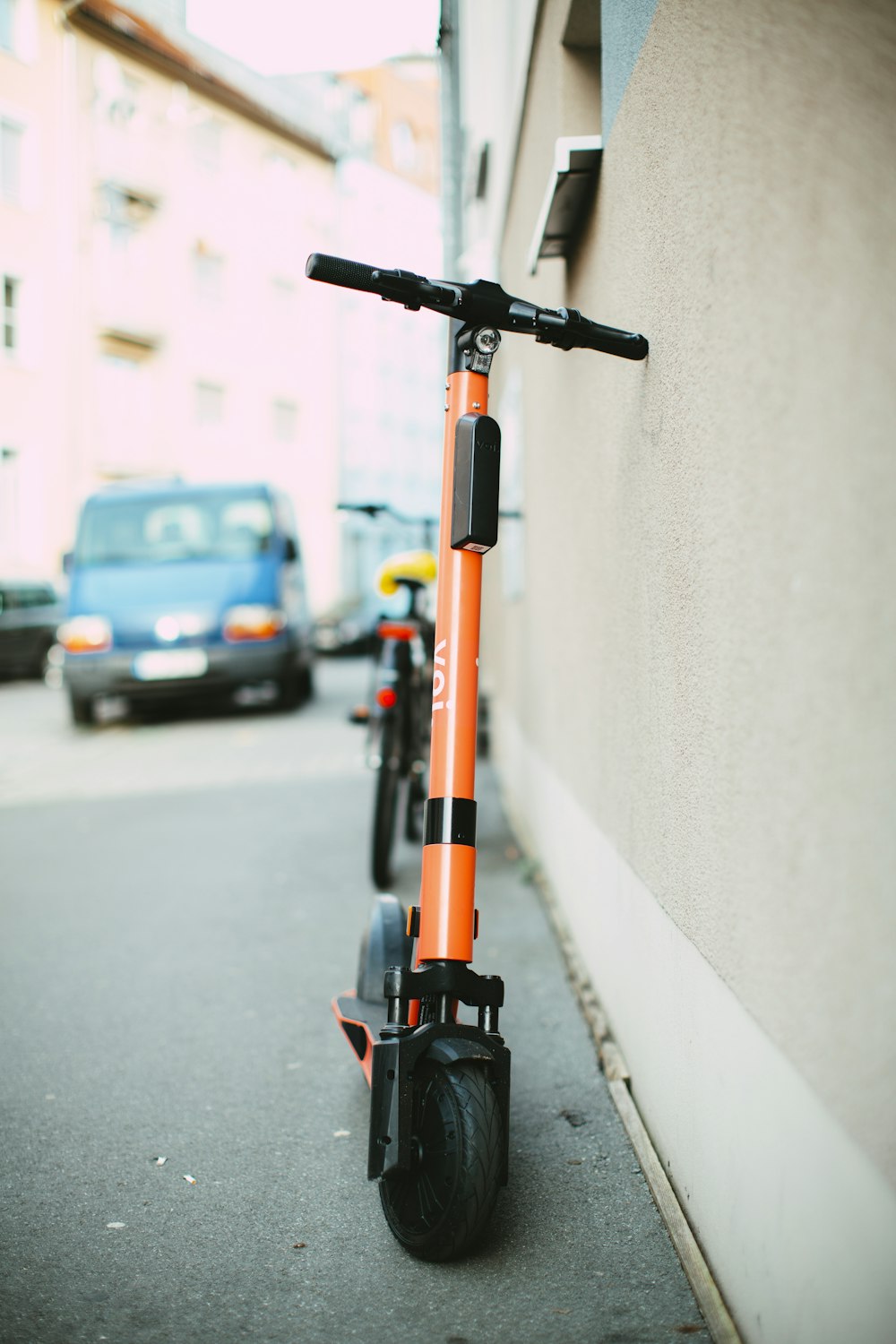 schwarzer und orangefarbener Roller auf dem Bürgersteig geparkt