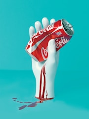 white hand holding Coca-Cola can statue