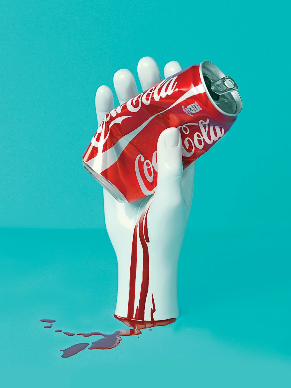 mão branca segurando estátua da lata de Coca-Cola