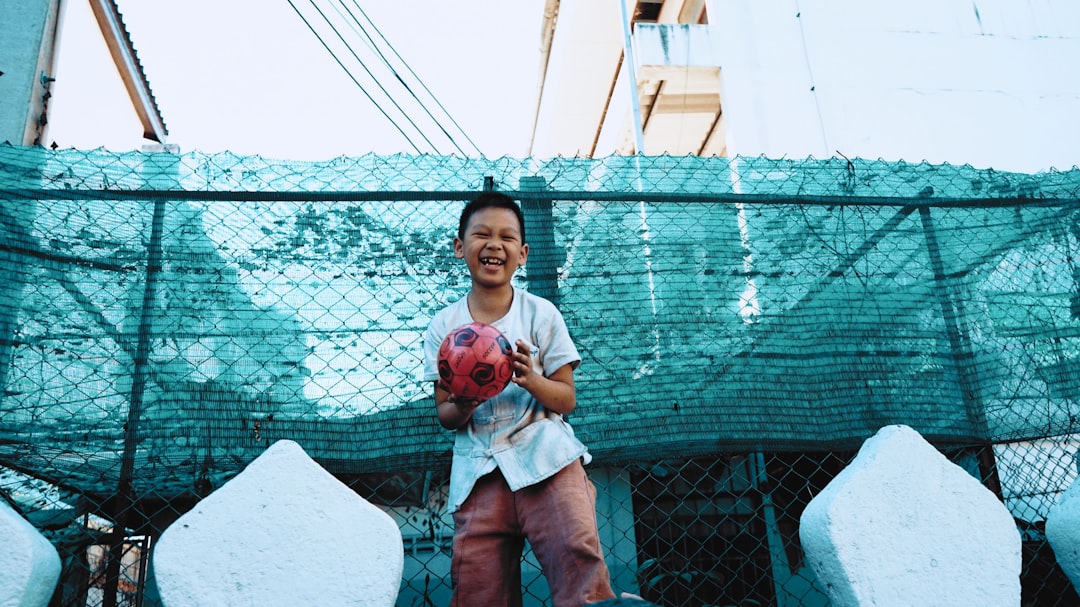 boy holding a black and red ball