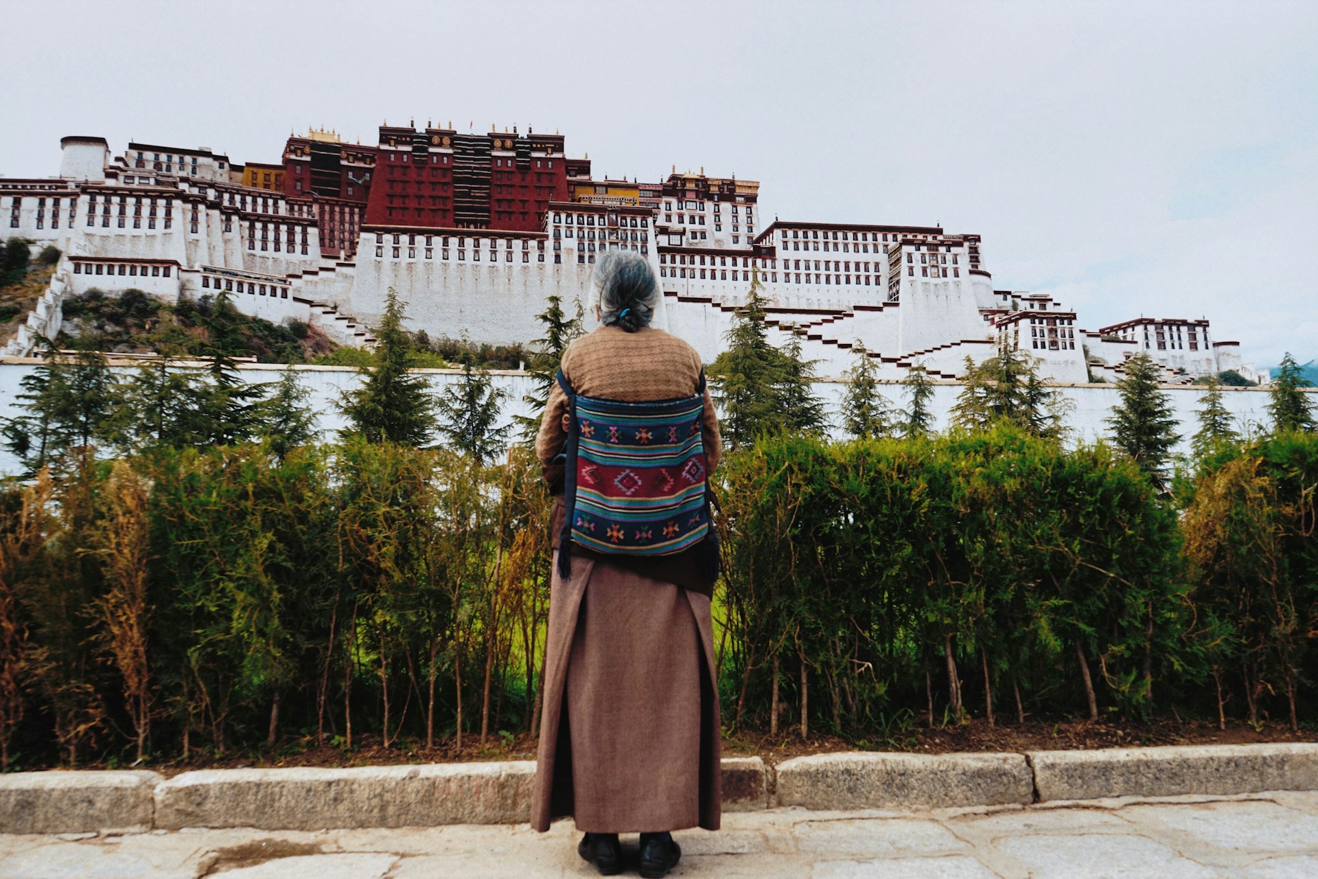 woman looking up at a concrete building