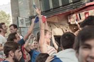 Fans waving flags and wearing team colors in a lively outdoor viewing party.