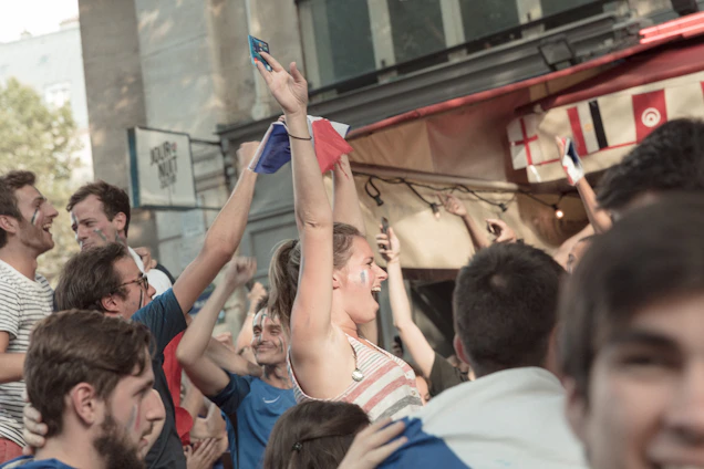A lively crowd enjoying cultural and sports activities at the Festival du Lion, with colorful banners and smiling faces.