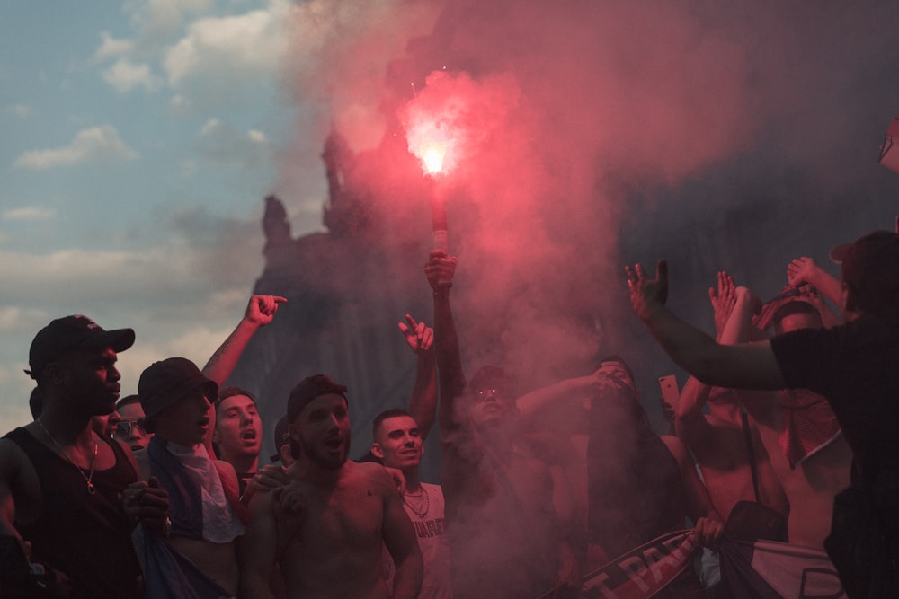 a group of people holding flarers in front of a building