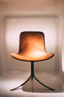 Wooden banquet chair with curved backrest and cream upholstery, blending comfort and style.