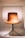 A modern, stylish chair with a curved wooden back and seat, supported by sleek metal legs. The chair's warm brown color is highlighted against a soft, neutral background.