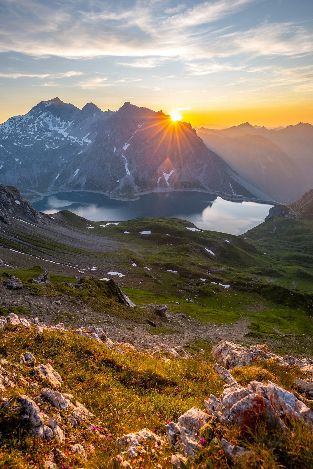 body of water near mountains during golden hour