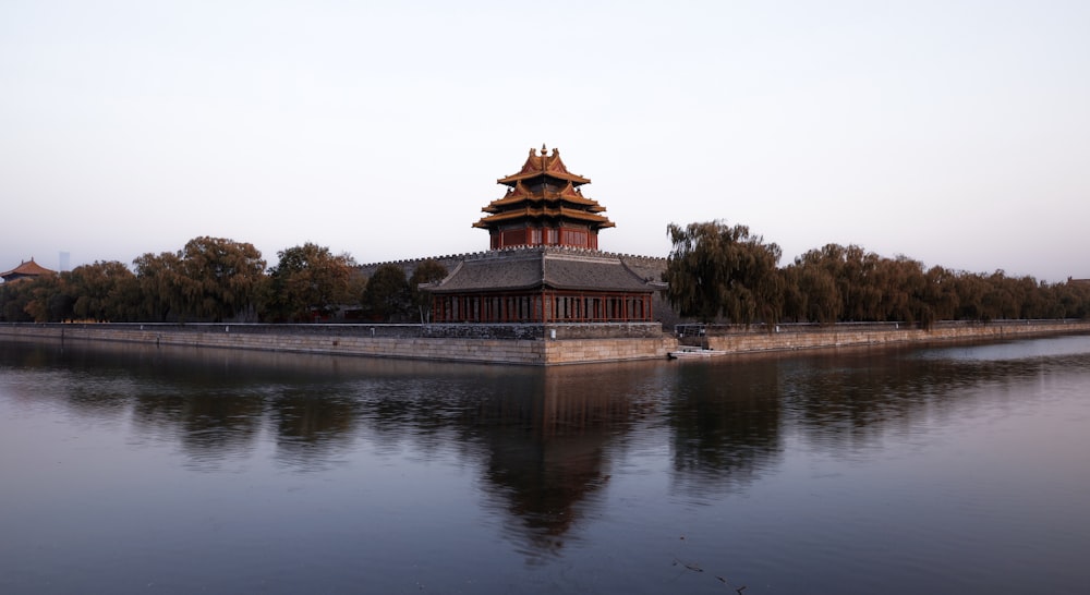 architectural photography of brown and red house near body of water