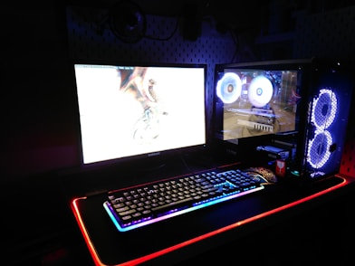 two black flat screen computer monitors and gaming keyboard