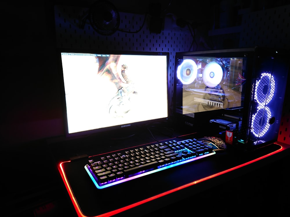 two black flat screen computer monitors and gaming keyboard