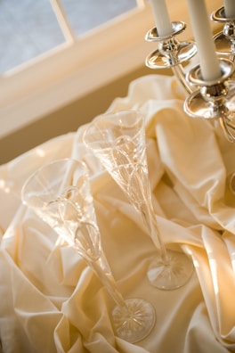 Artistic champagne flutes reflecting soft candlelight.