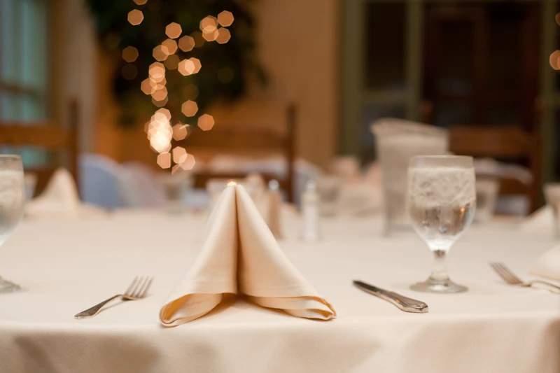 Long wedding table with greenery and glassware.