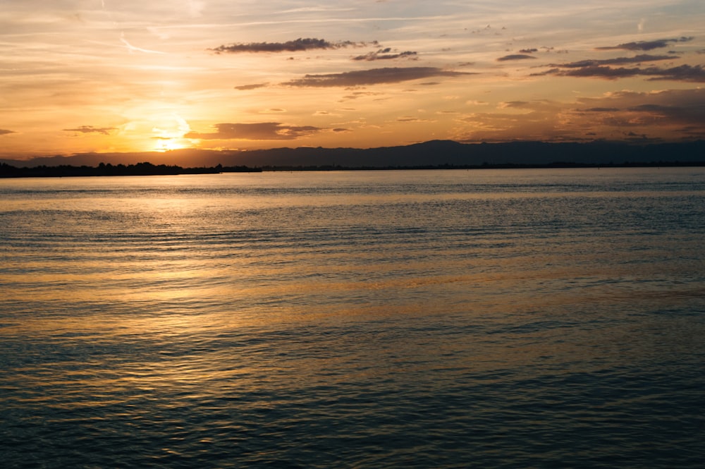 body of water and silhouette of mountains