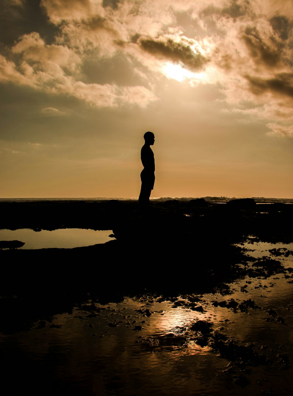 silhouette of person standing on rock