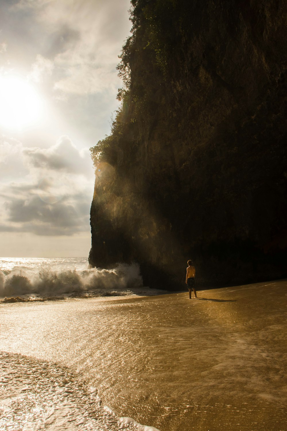 a person standing on a beach next to the ocean