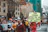 A group of people are participating in a climate change protest on a city street. Several individuals hold signs, including one prominently displayed that reads 'Cut your carbon? Pledge to be flight free in 2020.' The participants appear to be diverse in age and are dressed casually.