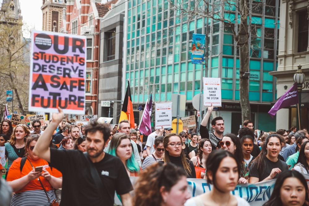 people protesting near buildings during day