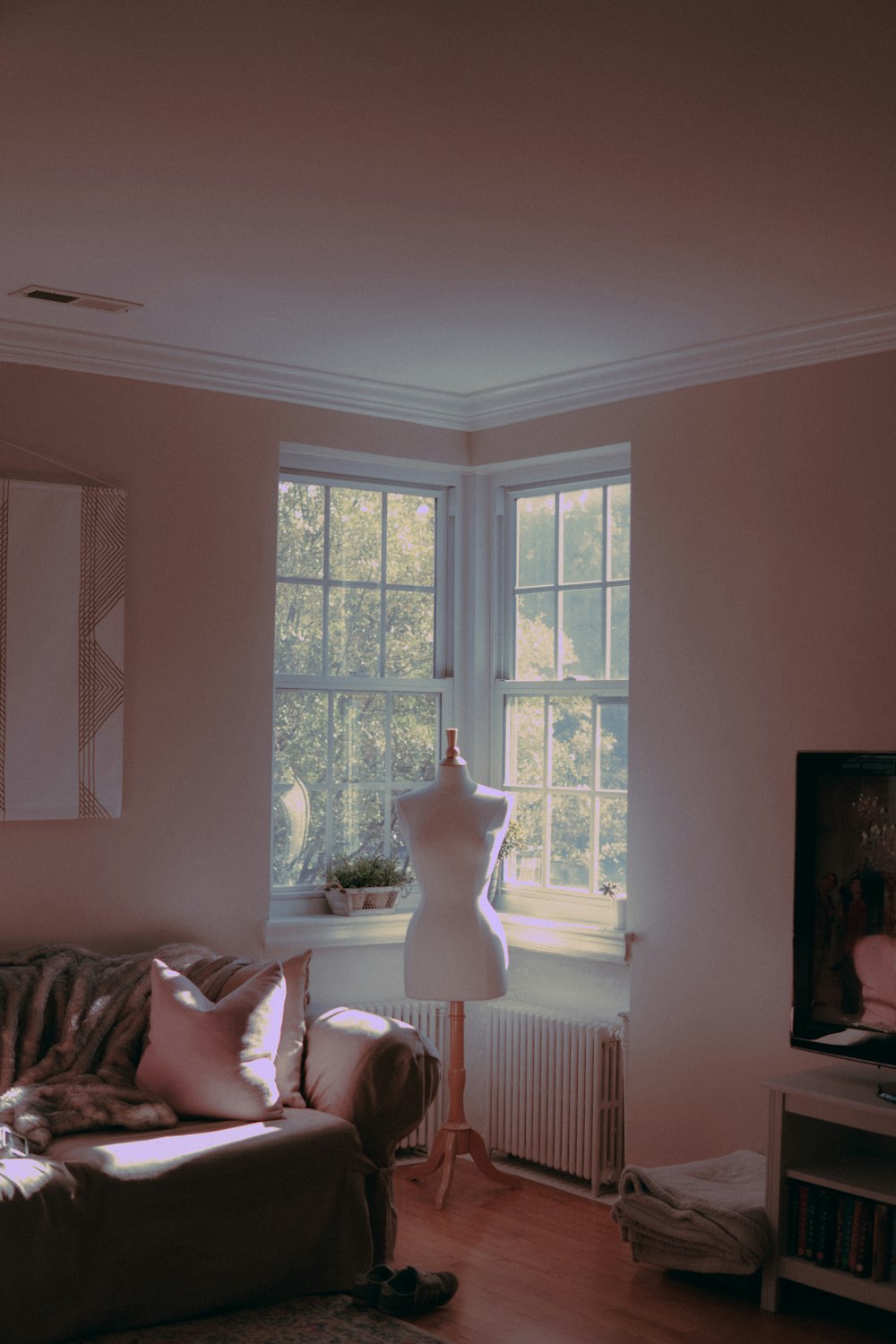 white dress form beside sofa inside room