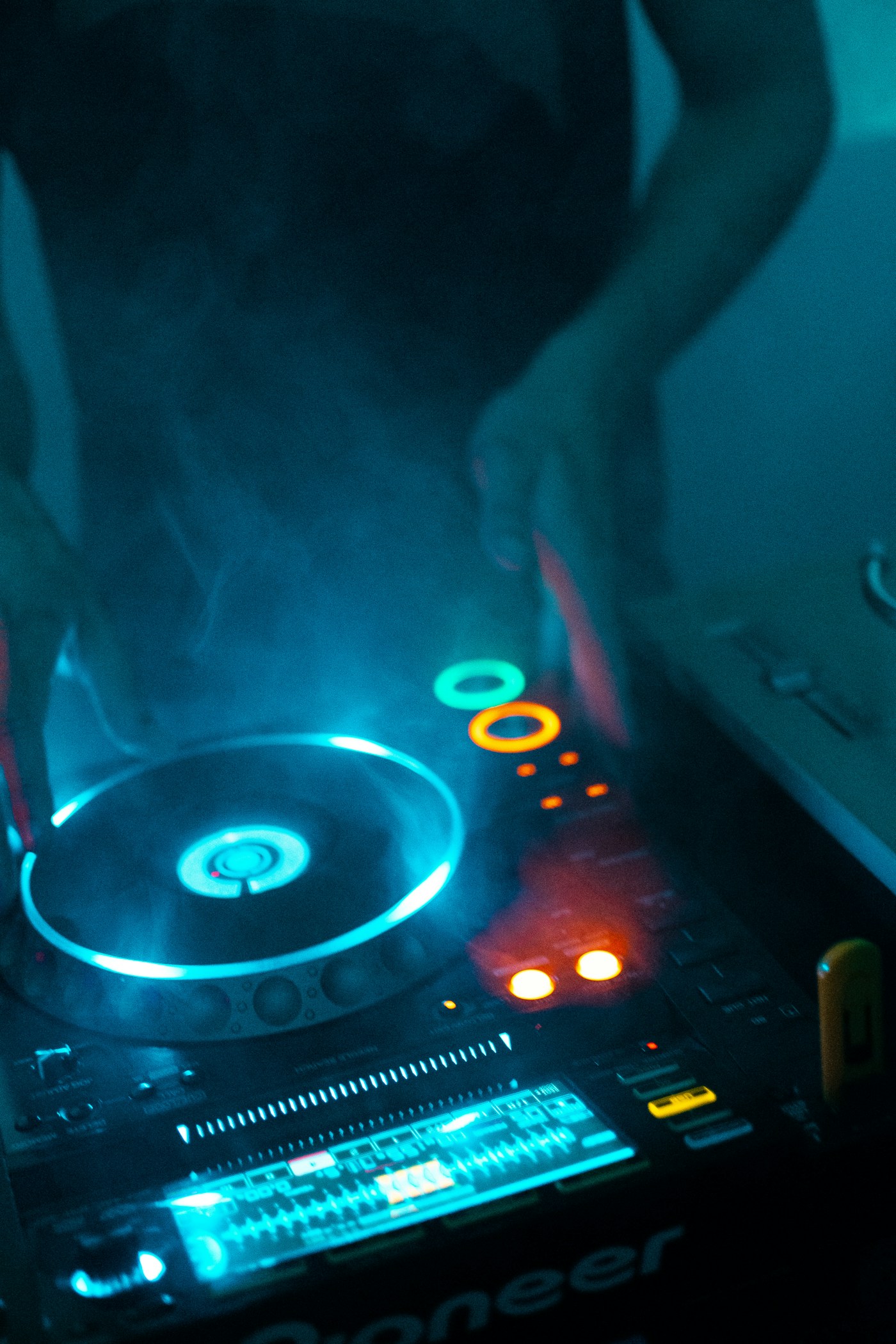 DJ performing at concert with atmospheric lights