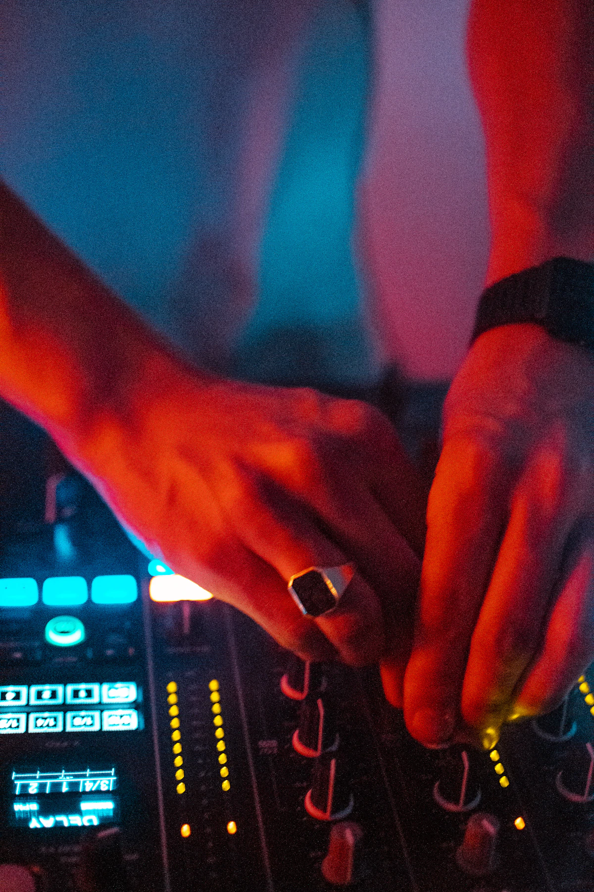 A DJ's hand working turntable controls during a live set