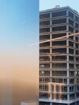 Wide shot of a towering concrete structure under construction at sunset.