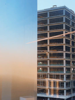 Wide shot of a towering concrete structure under construction at sunset.
