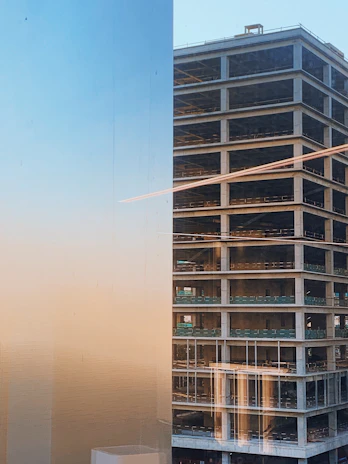 A panoramic view of a modern residential building under construction at sunset.