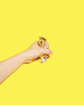 A warm, inviting portrait of a smiling team member holding a freshly made Snickers bar.