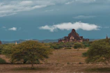 Historic architecture of an ancient temple nestled among green fields.