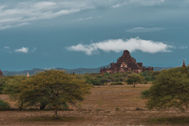 Historic architecture of an ancient temple nestled among green fields.