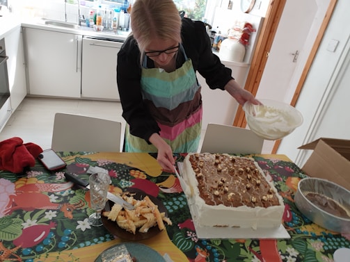 A pastry student carefully decorating a cake in the academy's kitchen.