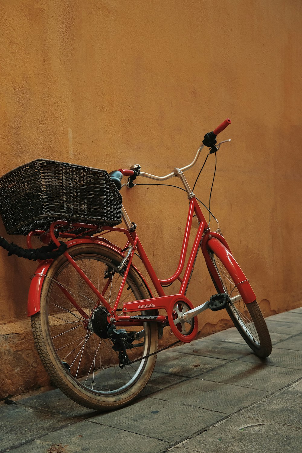 red commuters bike beside wall