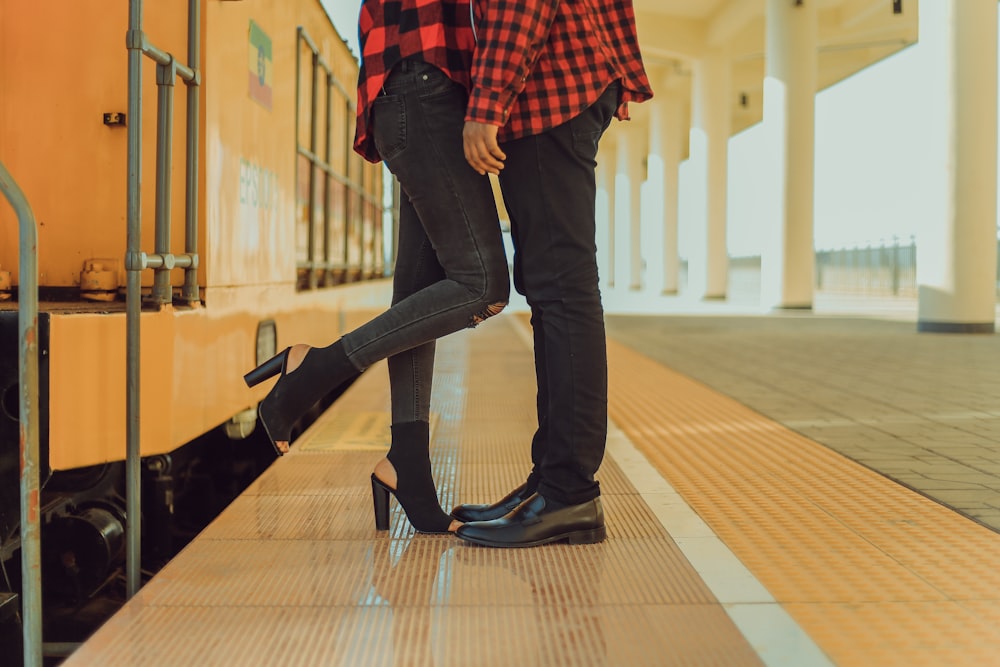 view of couple wear red-and-black sport shirts at the train station