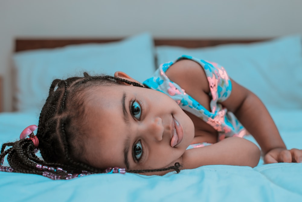 menina deitada na cama com a língua saindo