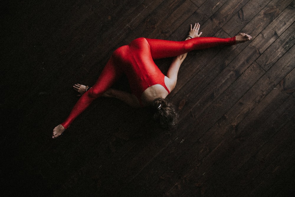 woman splitting and lying forward on parquet floor