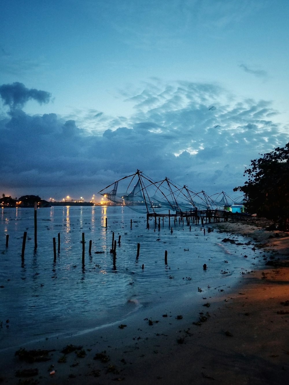 a beach at night with a pier in the background