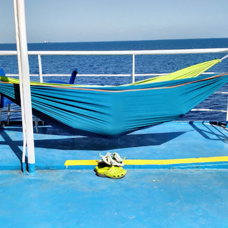 A close-up of stylish cruise shoes lined up on a ship’s balcony floor with the ocean in the background.