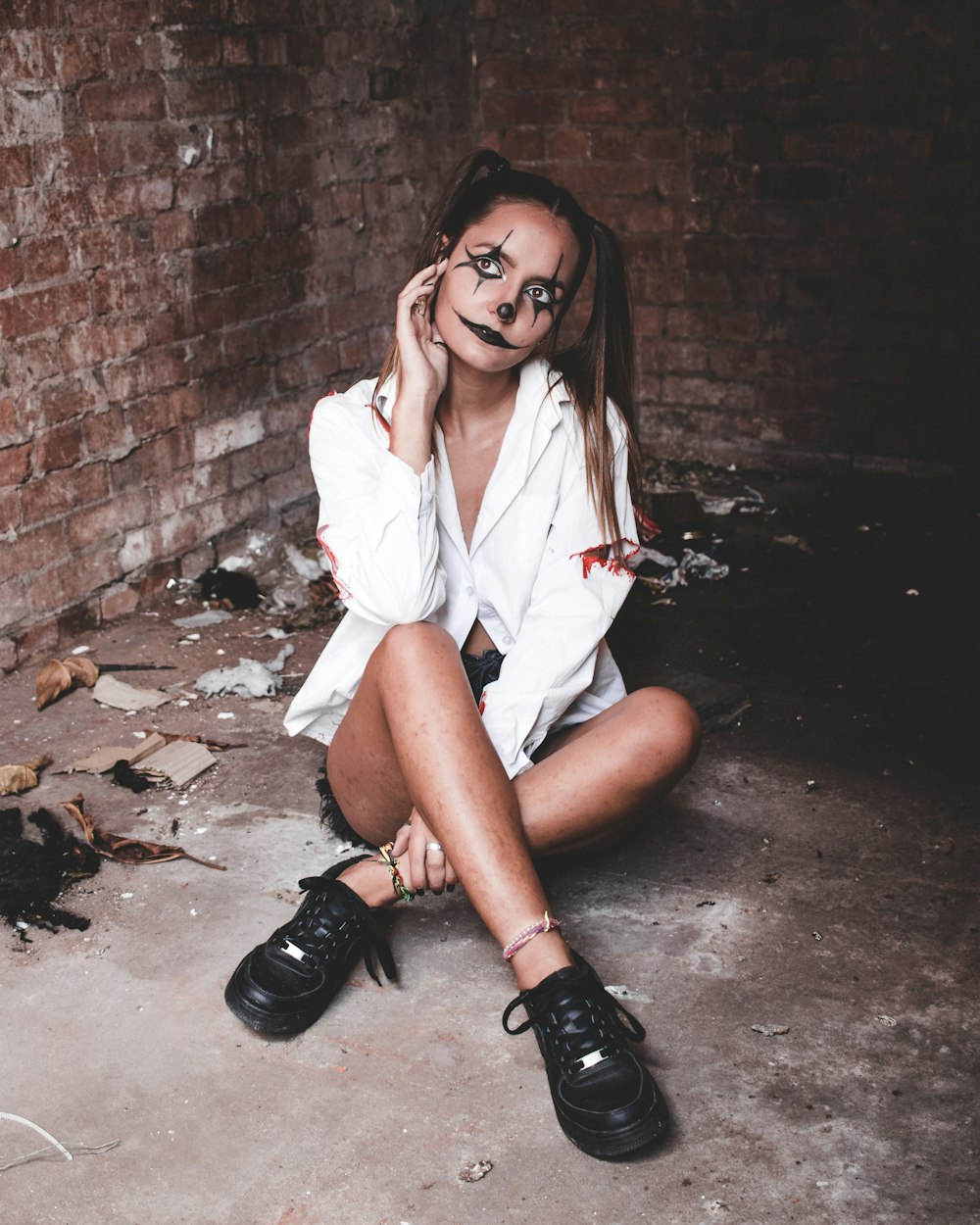 a woman with painted face sitting on the ground