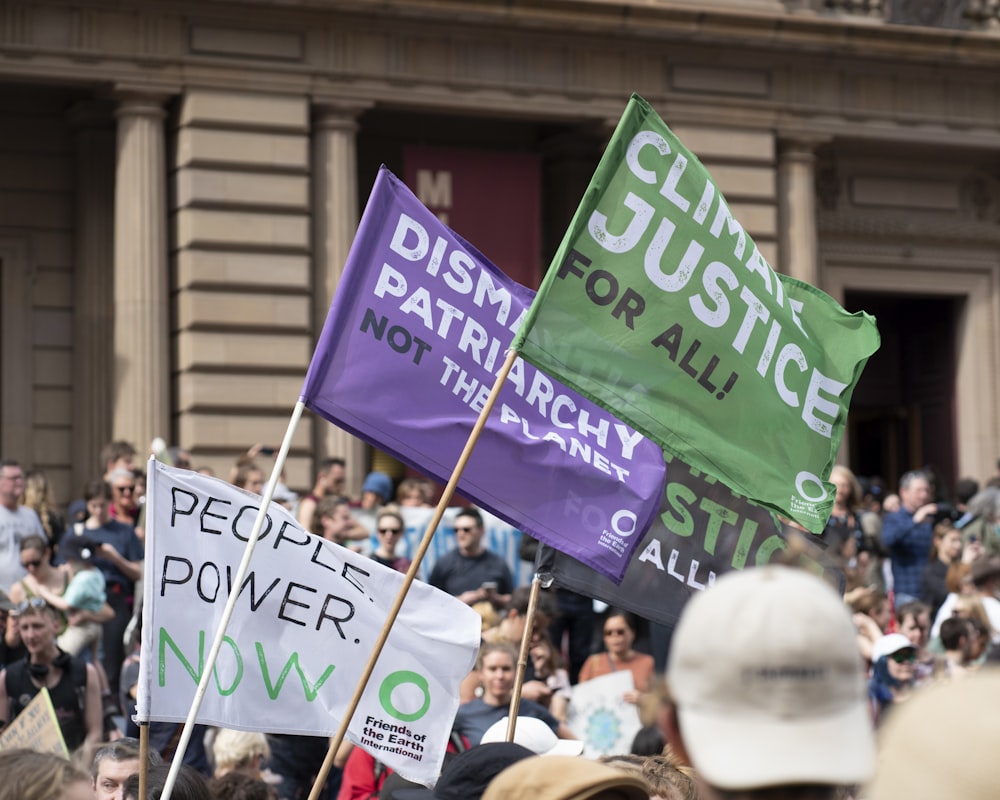 a group of people holding signs in front of a building