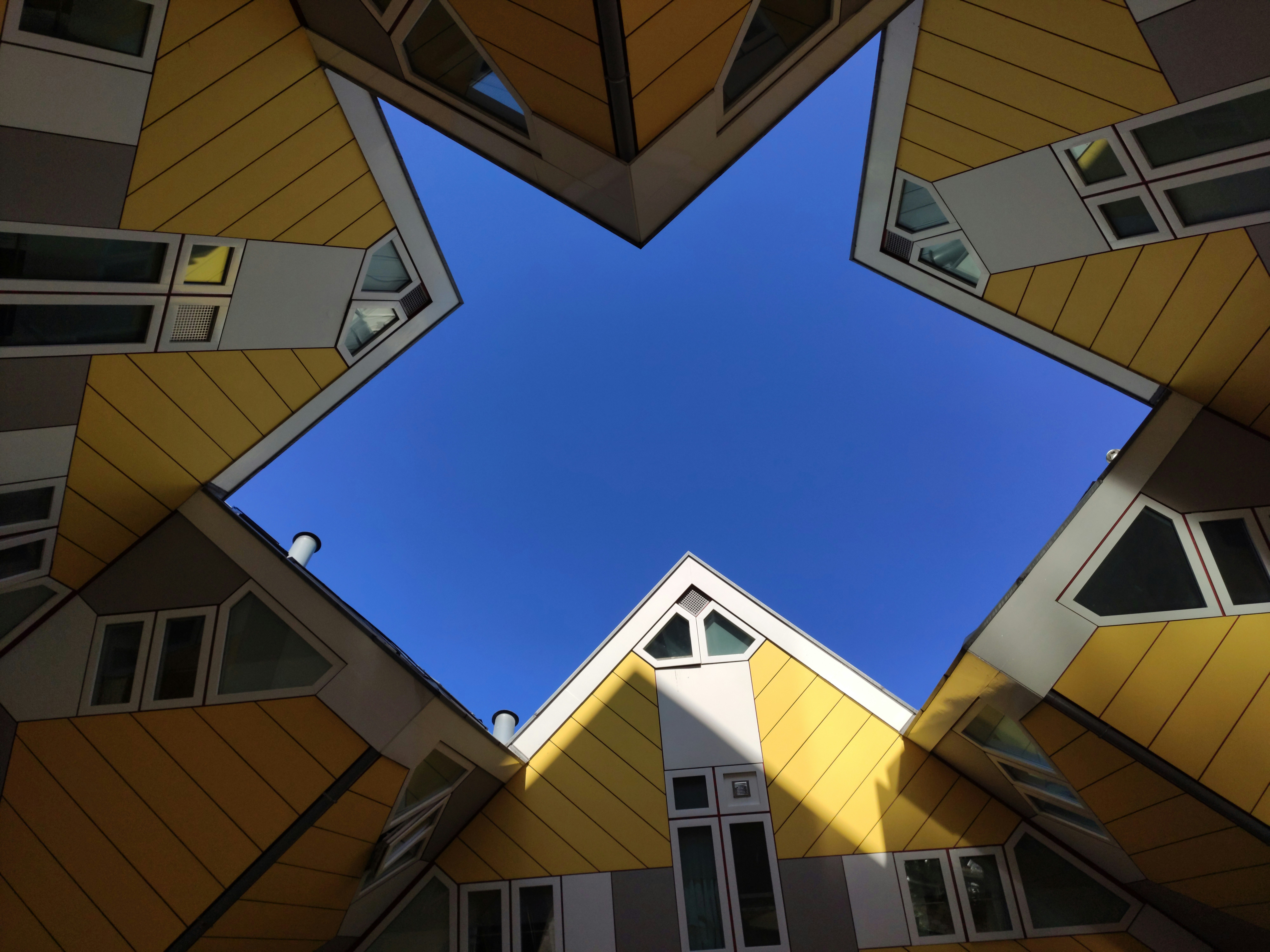 low-angle photography of yellow-and-gray houses during daytime