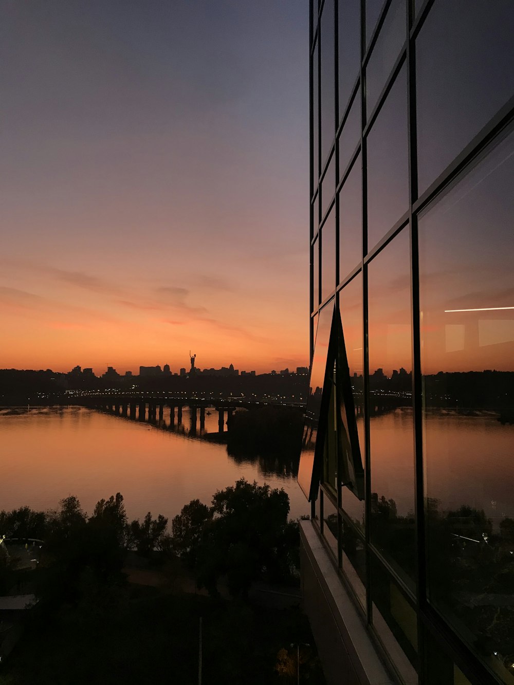 a sunset view of a river and a bridge from a building