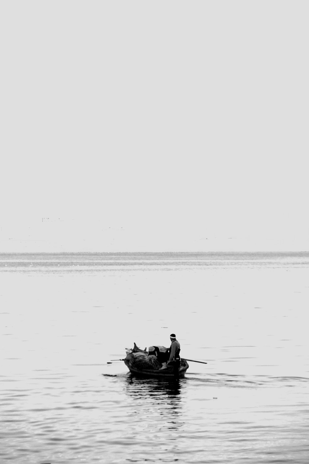 grayscale photography of man riding on boat