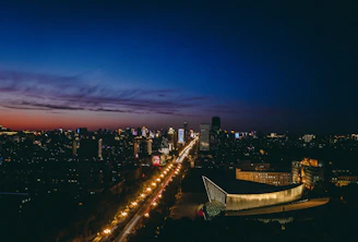 A student standing at the start of a illuminated career roadmap under a city skyline glowing at dusk.