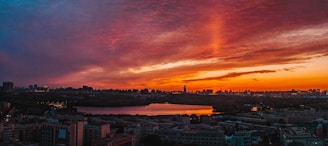 A vibrant sunset over a city skyline, with neon lights reflecting on the buildings, evoking a retro-futuristic atmosphere.