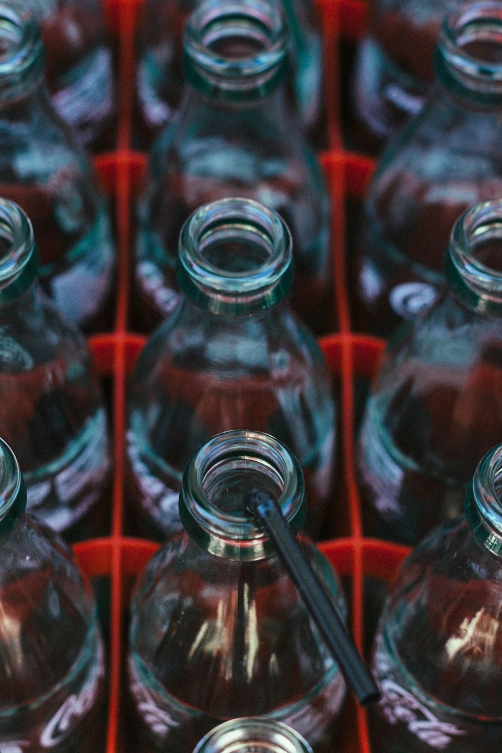 selective focus photography of clear Coca-Cola glass bottles