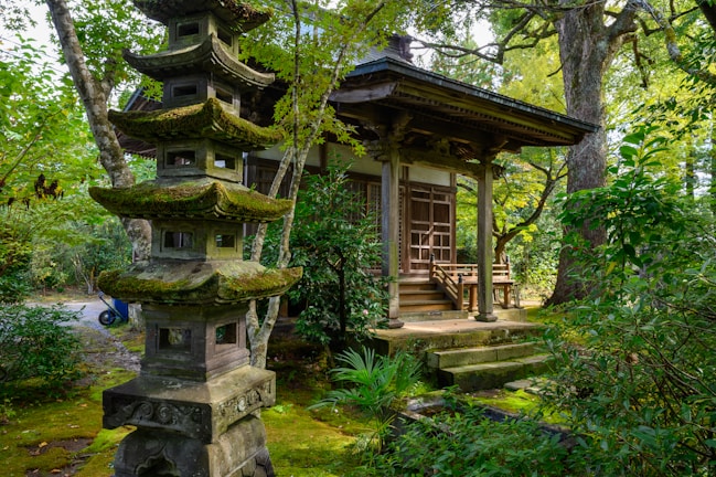 Miki standing quietly in the temple courtyard at dawn, surrounded by ancient stone lanterns.