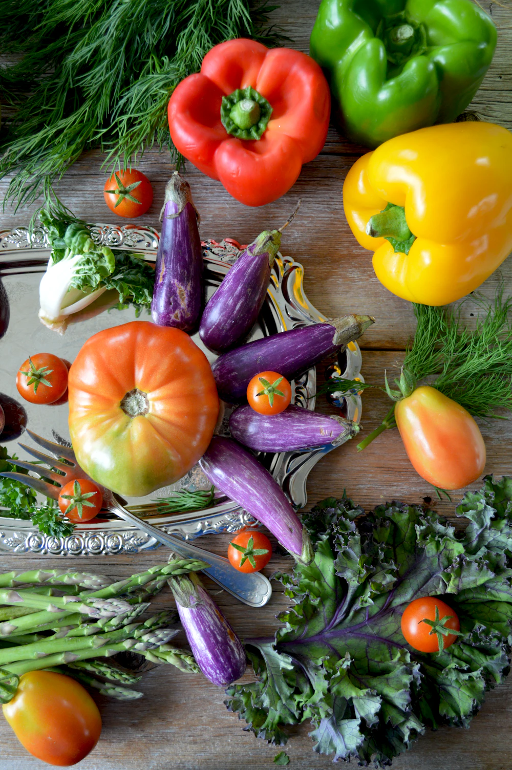 Freshly pulled heirloom vegetables and herbs laid out on a rustic table in soft natural light