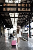 woman holding pink luggage